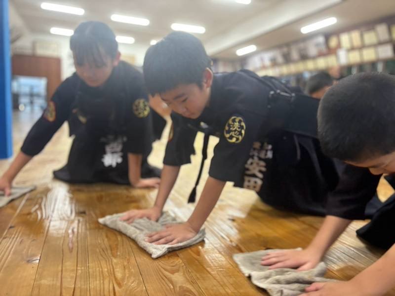 稽古の前に道場の床を雑巾がけする少年剣士たち