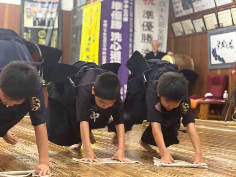 道場の床を雑巾がけする少年剣士たち